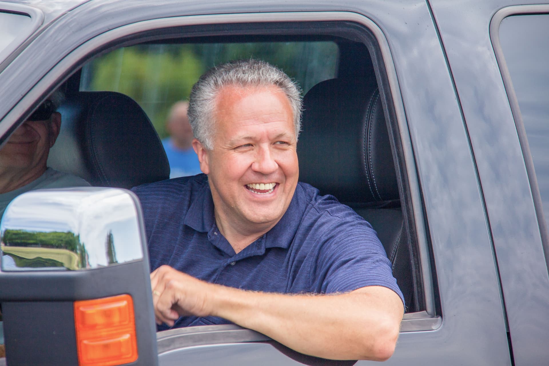 Mike Gaskill smiling from his truck window while out in the district